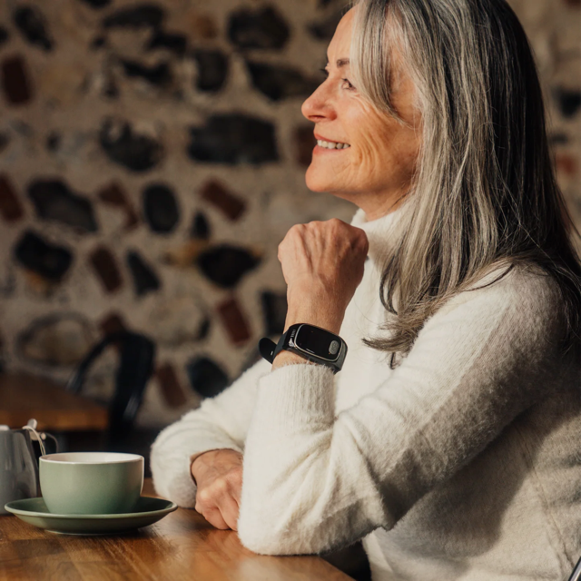 Elderly woman wearing SentraCare SafeStride watch, living independently